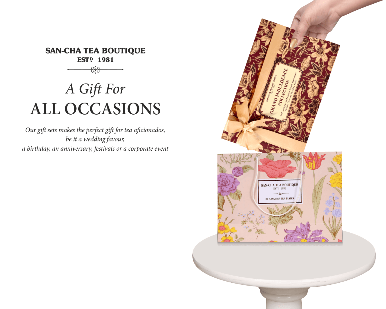 Tea gift set with floral design on a white pedestal against a black background, featuring 'San-Cha Tea Boutique' branding.