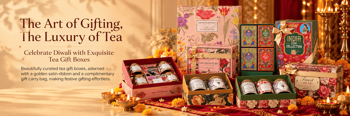 A festive tea gift box display with multiple colorful floral-patterned boxes, small tea tins, and a gold ribbon, styled on a decorated table with candles and marigolds. Large text on the left reads, 'The Art of Gifting, The Luxury of Tea.
